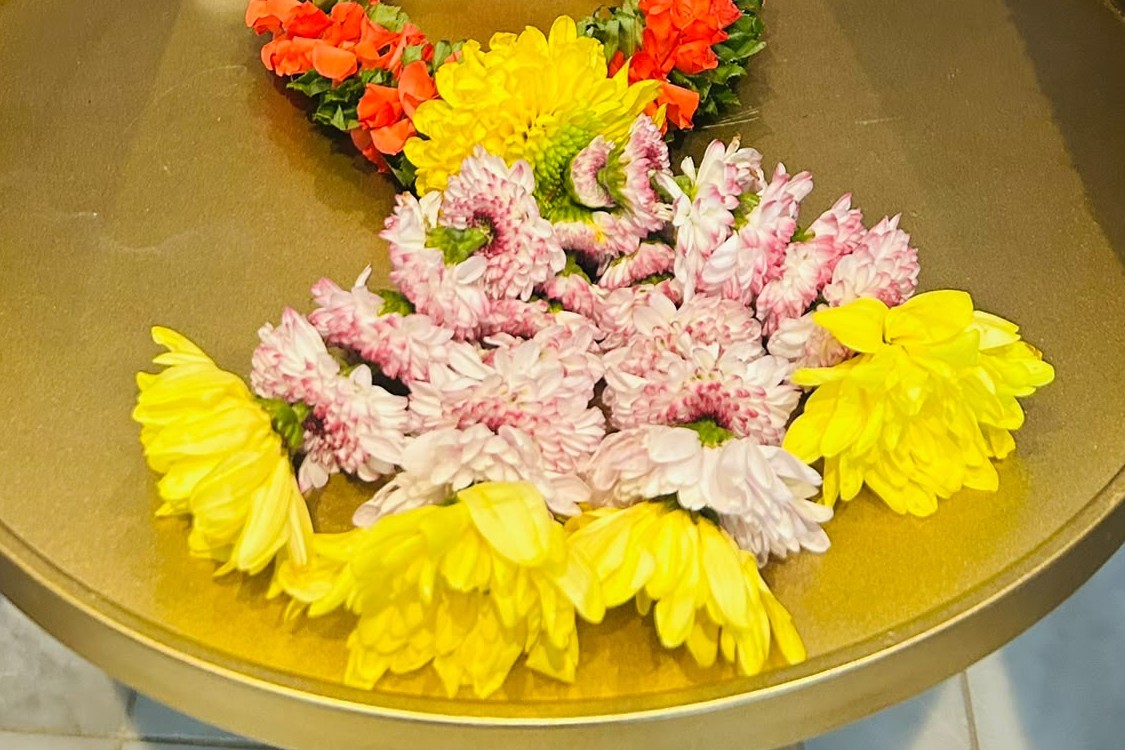 Roze, gele en oranje bloemen en een bloemenslinger op een gouden tafel